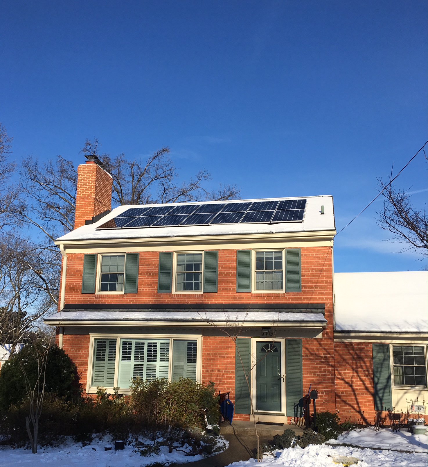 Cute home with solar panels in the snow